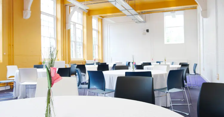 Penton room showing bright room with big windows, cabaret set up with round tables and white table cloths