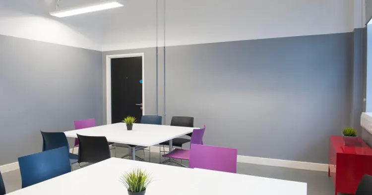 Cabaret set up for 12 people - white table, grey walls, purple and navy chairs