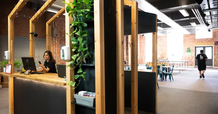 Lift ground floor hall with receptionist using laptop and phone in foreground