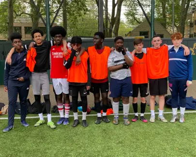 Nine boys in a row wearing football gear