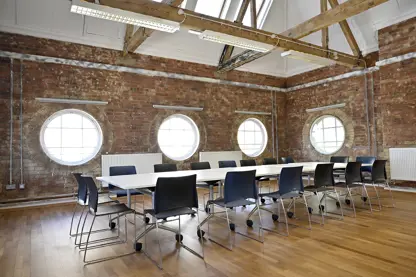 Long whote table with chairs set up for a board room meeting