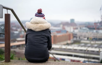 Back of person sitting on steps looking out over the city